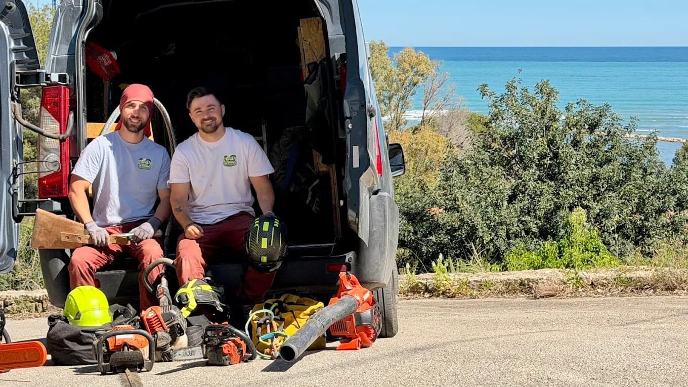 El equipo de Los Hermanos sentado en su furgoneta, con su material de poda, frente al mar
