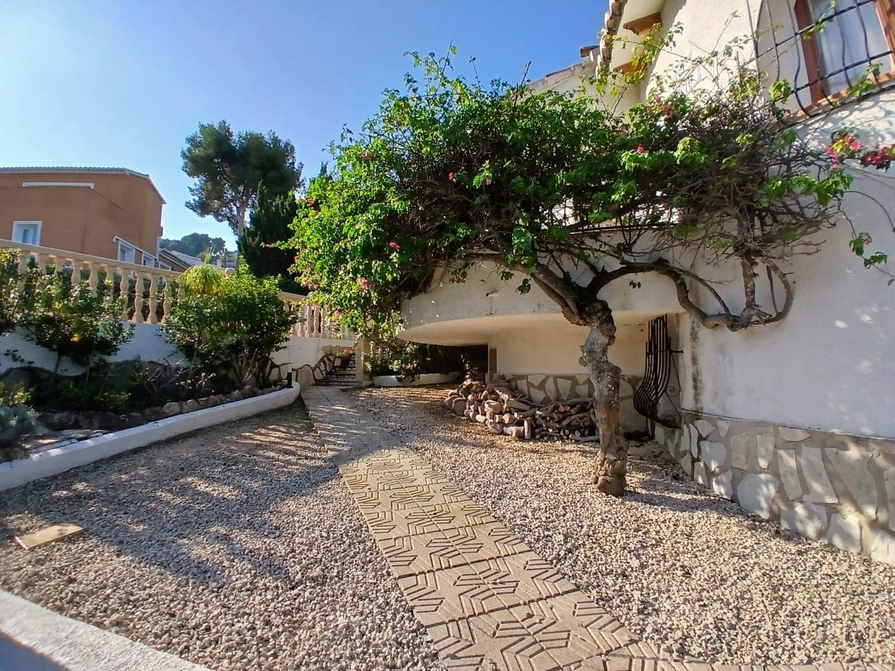 Camino de grava con losas bajo una pérgola de buganvilla en un jardín mediterráneo diseñado